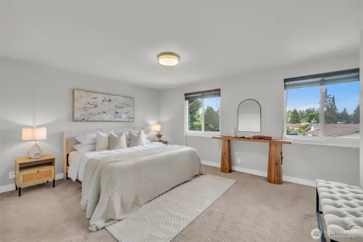 Spacious primary bedroom with large windows and an en-suite bathroom