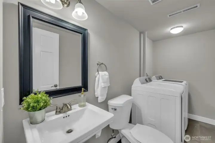 Practical lower-level half bathroom and laundry space with ample room for appliances