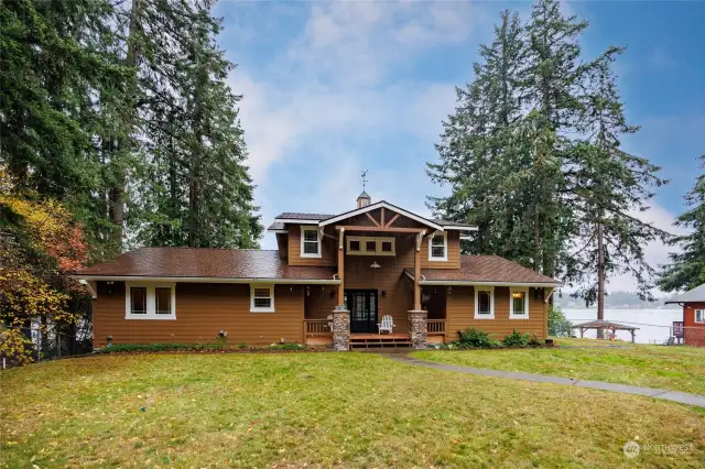 Front of home with covered porch and large yard to enjoy.