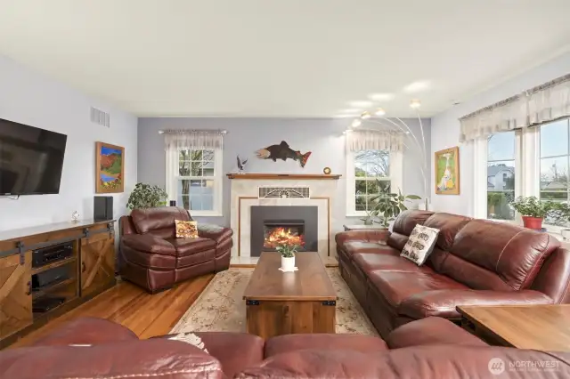 Living room features a cozy gas fireplace with a bright and sunny bay window