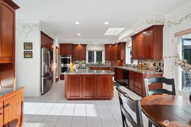 A huge kitchen with stainless steel Refrigerator, double oven, electric cook top, Cherry cabinets, and walk in Pantry.
