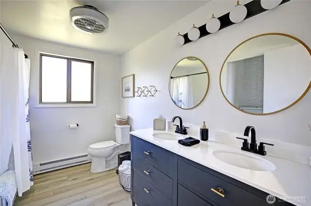 NEWLY remodeled bath features new flooring, custom double vanity w/designer fixtures + fun lighting package.
