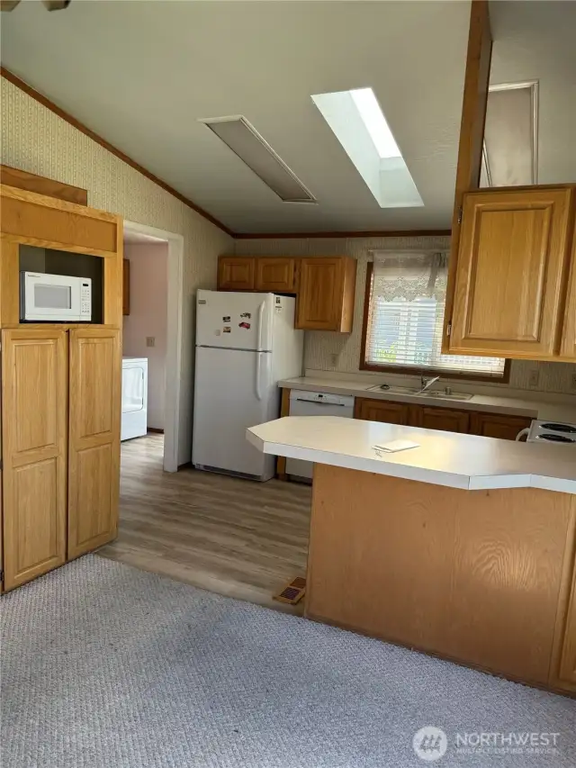 Another view of the kitchen looking at pantry and doorway to utility room.