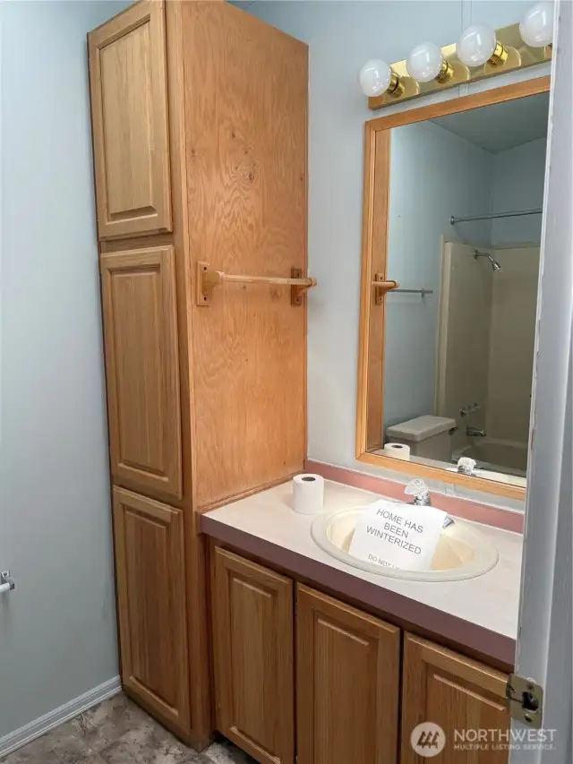 View of half of the double vanity primary area and linen closet.