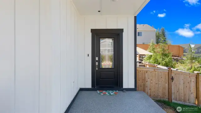 The huge covered front entry and gated, wide side yard make a distinctive first impression. The striking black front door sets the tone for the entire home.