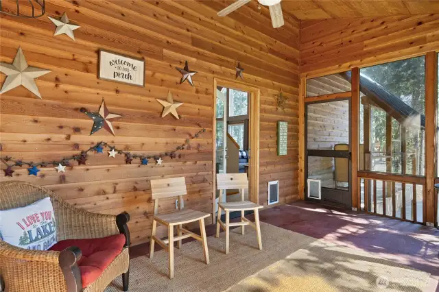 Step through the screen door onto the front deck with firewood storage, perfect for cozy winter days.