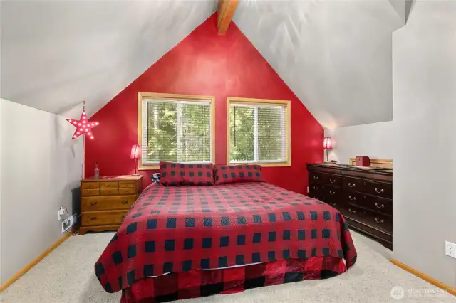 The primary bedroom features vaulted ceilings and beautiful exposed wood beams.