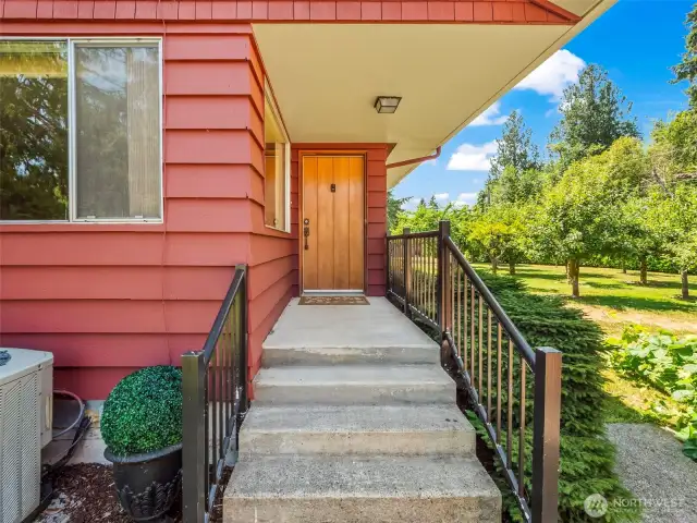 Original front solid door. Fruit orchard to the right