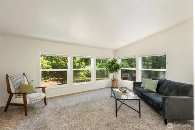Large windows on two wall in living room provide natural light and a view to the orchard.
