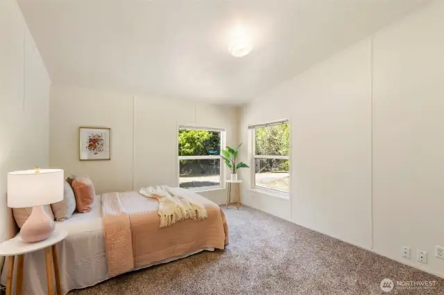 Large primary bedroom with vaulted ceilings and neutral colors.