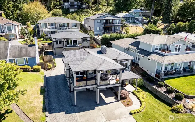 Sophisticated coastal design meets small-town charm with expansive decks and a separate guest retreat above garage.