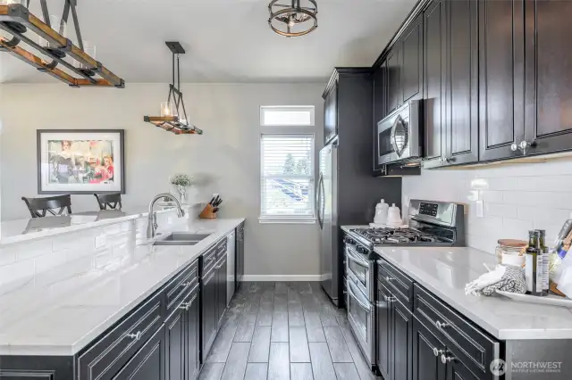 Impeccably crafted kitchen with rich cabinetry, designer lighting, and sleek surfaces for entertaining in style.