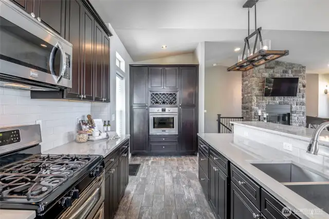 Designer kitchen with custom cabinetry, built-in wine rack, and views straight through to the stone fireplace.