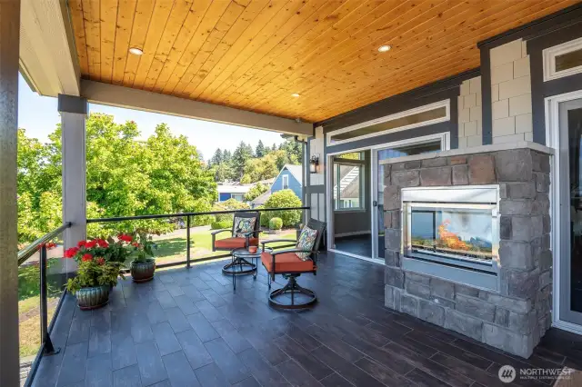 Cozy up by the outdoor fireplace and savor peaceful views from this inviting covered deck.
