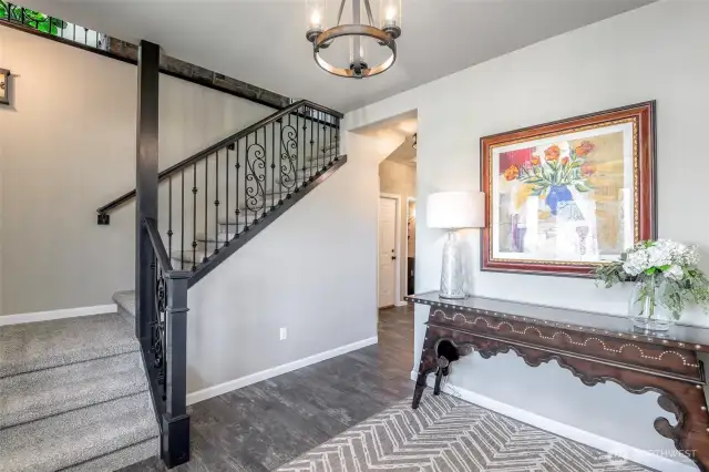 Stylish entryway with wrought iron details and warm finishes sets a charming tone from the start.