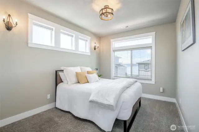 Wake up to tranquil water views and soft natural light in this cozy, serene bedroom retreat.