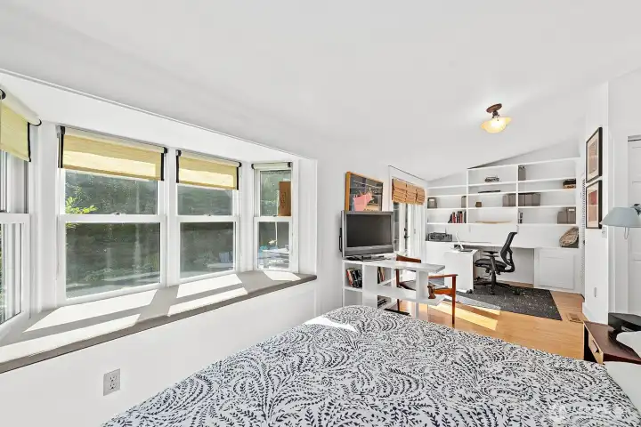 The primary bedroom is large and comfortable with a walk-in closet and a bath at hand. The area at the far side of this photo can serve as a home office or yoga & exercise space.