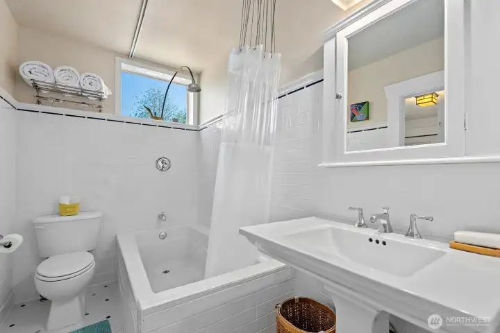 This guest bath is also finished in the period style of white subway-tile keeping both bathroom finishes consistent with each other. This bath features a tub/shower combination which is always nice to have.