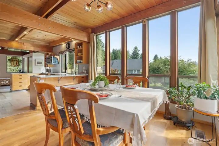 Dining open to kitchen with floor to ceiling windows
