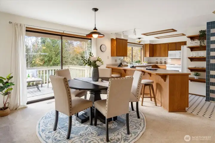 Sunlight fills the dining area and kitchen while sliding doors open to the elevated deck drawing the pastoral landscape into the heart of the home.