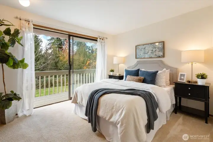 A serene main floor bedroom with sliding doors that open directly to pastoral views of lawn and treetops creating a quiet place to begin and end each day.