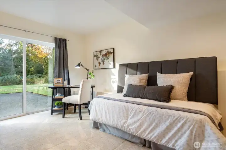 A versatile Garden Level bedroom or workspace with sliding glass access to a sheltered patio steps from the home’s expansive grounds.