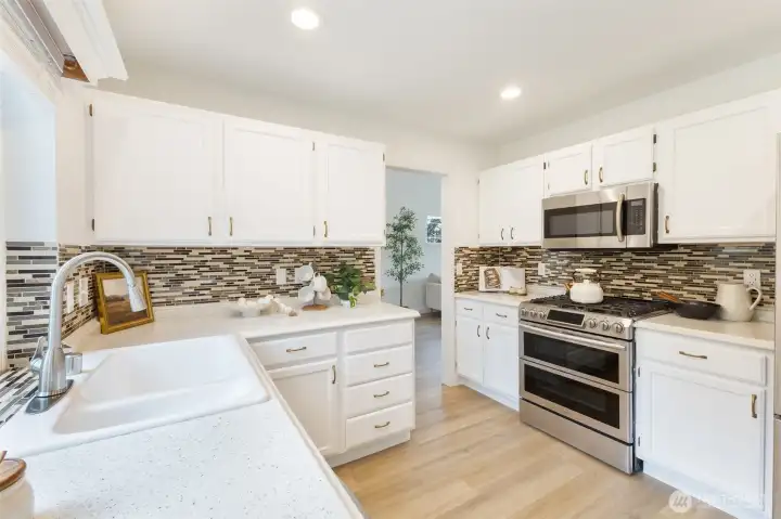 New countertops provide beauty and function, while the new cabinetry offers abundant storage. Stylish backsplash adds visual interest.