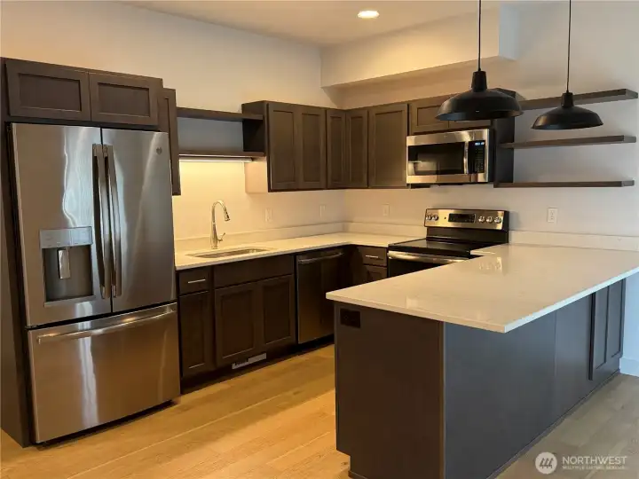 The kitchen is a nice one with stylish quartz and floating shelves as well as cabnitrey.