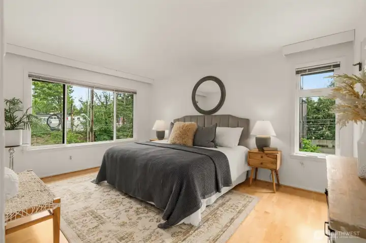 primary bedroom with natural light looking out to trees