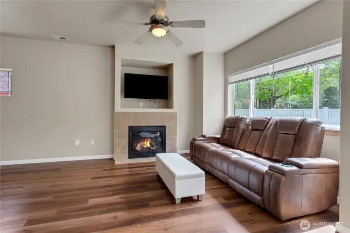 Comfortable living room just off the kitchen and dining area, featuring a cozy gas fireplace and large picture window that fills the space with natural light.