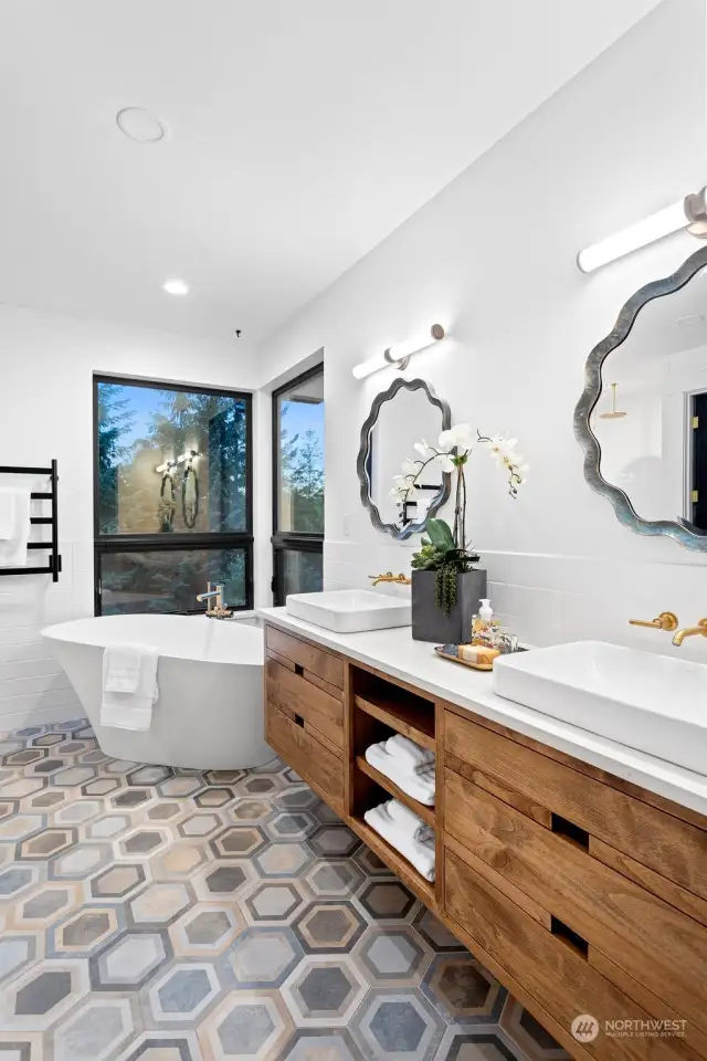 The master bathroom features a hexagon tile floor that seamlessly transitions into the shower, where simplicity meets practicality—no walls or glass enclosures make for easy cleaning.