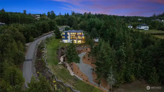 The curvy, upward approach adds to the charm, setting the stage for what lies beyond the gated entry front door.