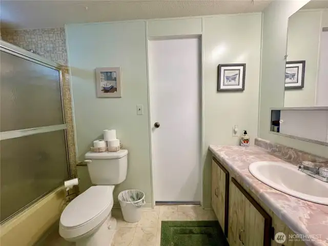 Guest bathroom which has a passthrough to the laundry room.