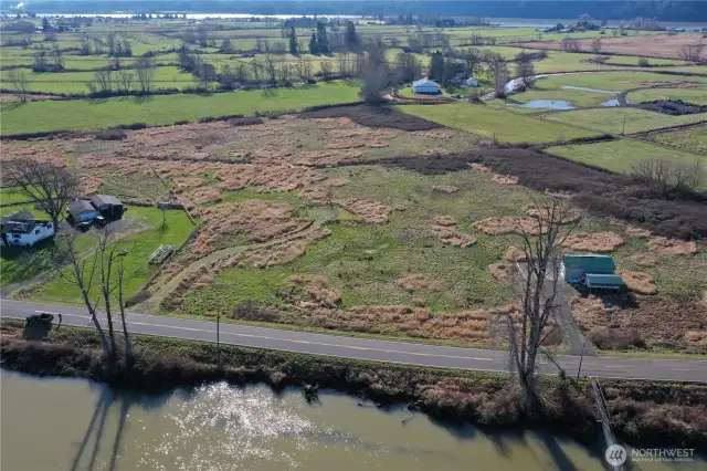 View from front of property showing rock-filled road into leveled area