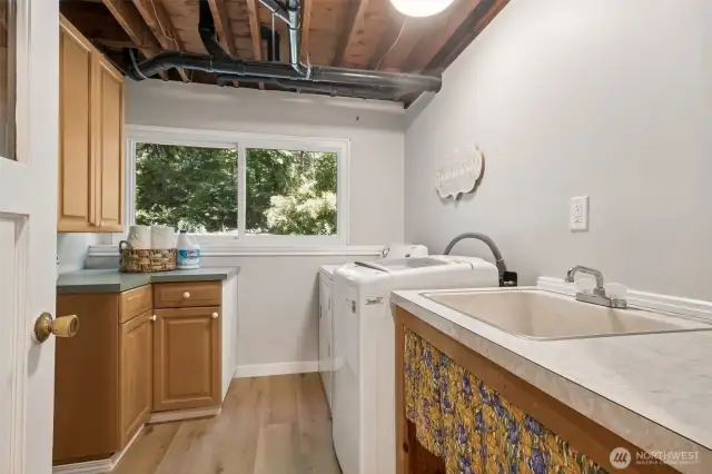 Large, bright laundry room with shelving, sink & counters!