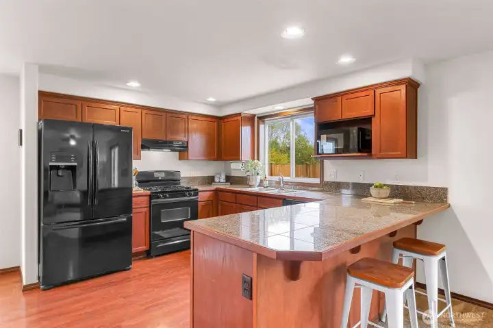 Granite tile counters and nice Cherry finish on the cabinets plus plenty of space to spread out at the eating bar.
