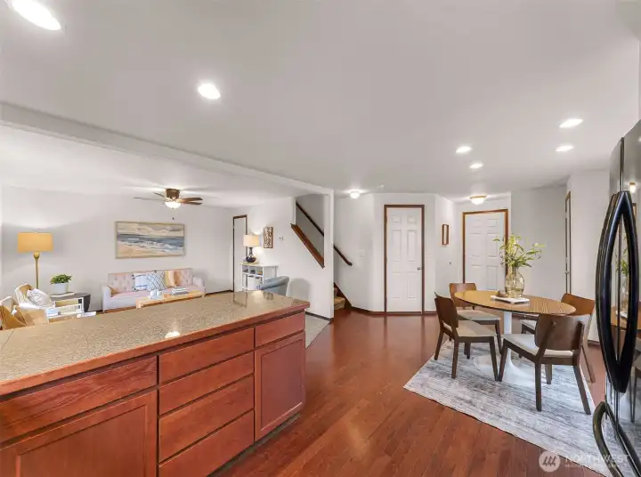 View showing the kitchen and dining spaces, the lighting and Cherry cabinets, stairs leading to upper level