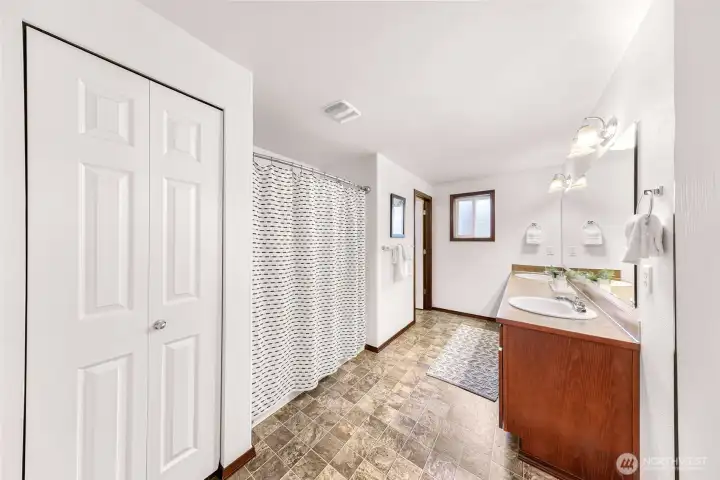 A very spacious bathroom!  Linen closet to your left, tub/shower and it's own toilet room with a door.  Two sinks along the large vanity and wait until you see the closet to your right!