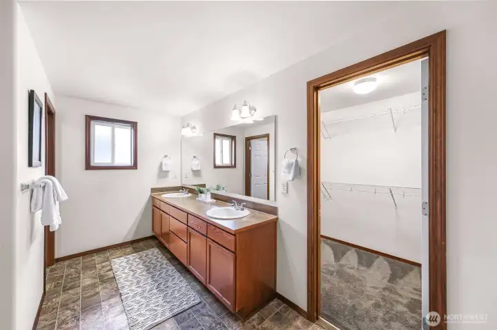 Another view of the double sink vanity and walk in closet door to your right.