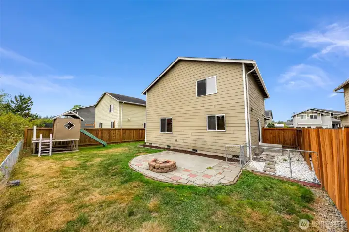 Playhouse to your left, patio at center and a fenced area off of the side porch.