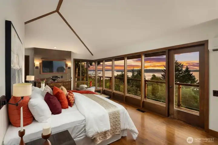 Primary bedroom features a vaulted ceillings, a hidden TV behind the mirror, a fully remodeled ensuite with two doors out to your private upstairs deck.