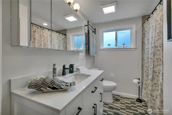Next up down the hall is this beautiful full bathroom.  The medicine cabinet is integrated with lighting, USB & anti-fog, the vanity has a pull-out drawer for your blow dryer, commode is bidet ready, towel warmer above, heated tile floor.