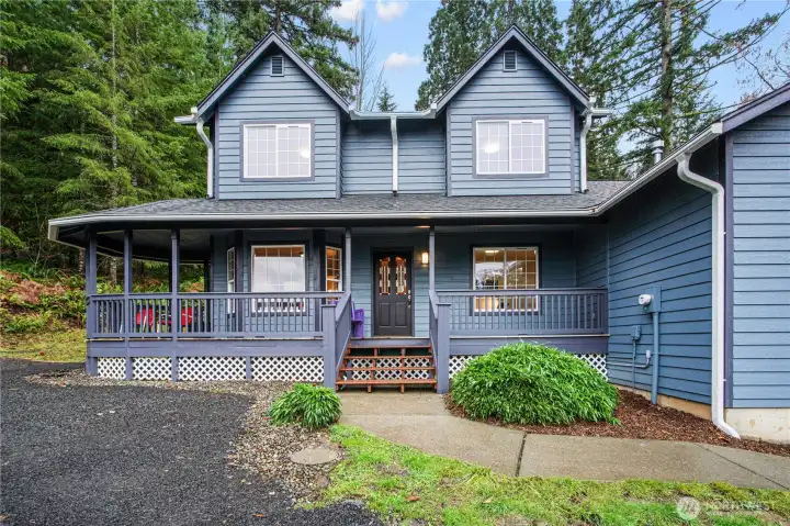 Charming front porch nestled among mature trees creates the perfect welcome home. A peaceful setting with timeless curb appeal.