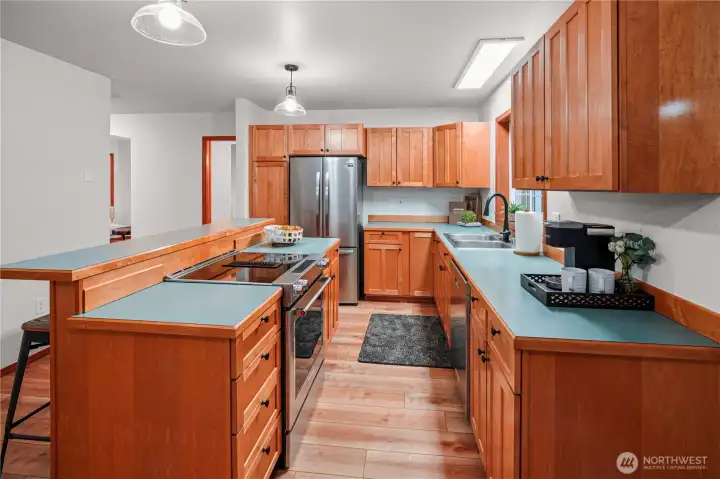 This angle of the kitchen showcases the ample counter space and impressive amount of cabinetry perfect for cooking and orginization.