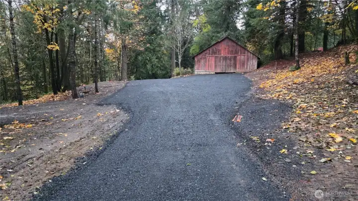 New black crushed rock driveway leading to barn.