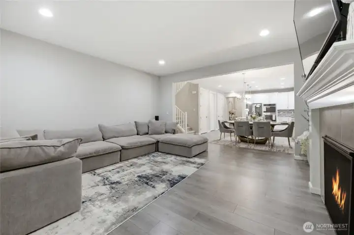 Spacious living room with gas fireplace opens to dining and kitchen