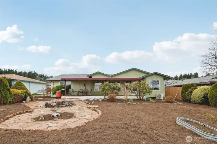 Front yard with brick and stone pathway, small fire pit, and covered porch.