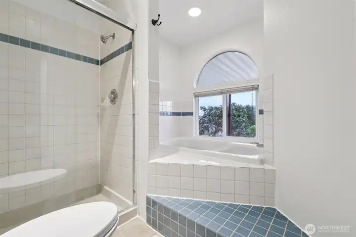 Primary en-suite bathroom with luxurious soaking tub and separate shower.