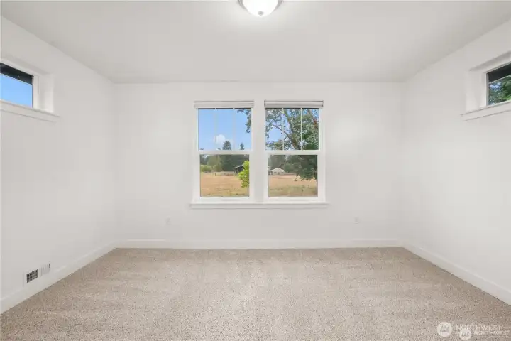 Upstairs bonus room alcove with large windows showcasing views of grazing cows across the street and a stunning backdrop of Mount Rainier.