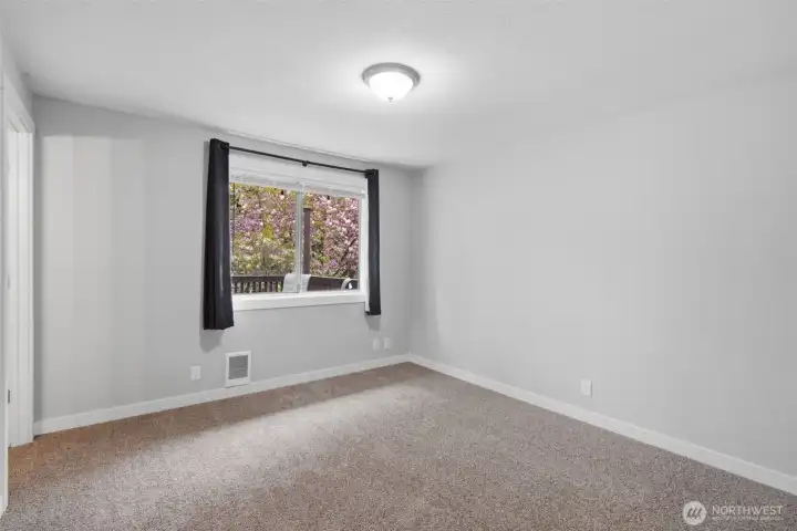 Primary bedroom has such a great view of the amazing back yard a foliage.